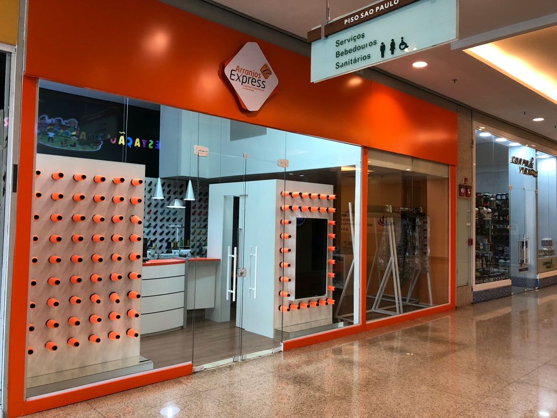Loja Arranjos Express em shopping com parede de carretéis laranja